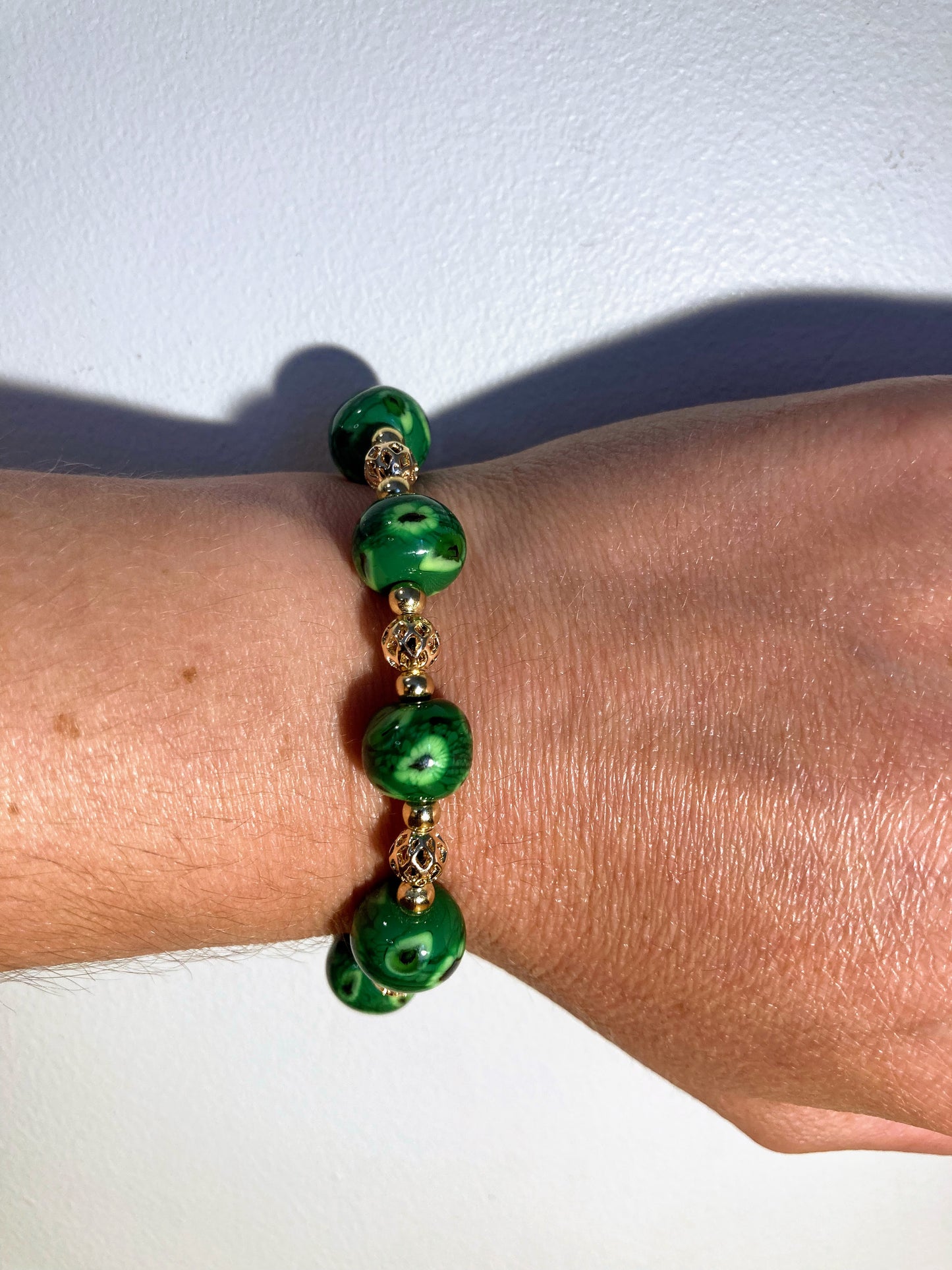 Bracelet doré avec perles vertes chamarrées en verre