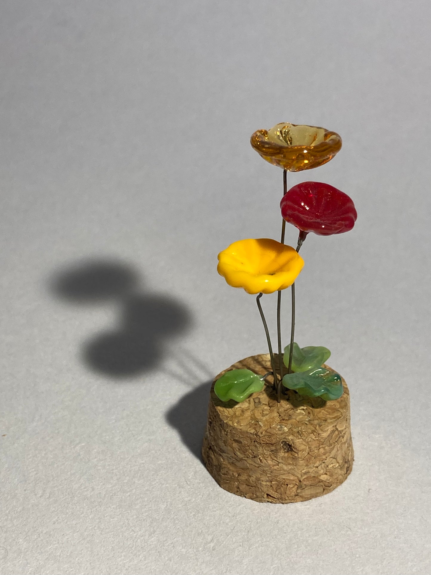 Fleurs oranges et rouges en verre sous cloches