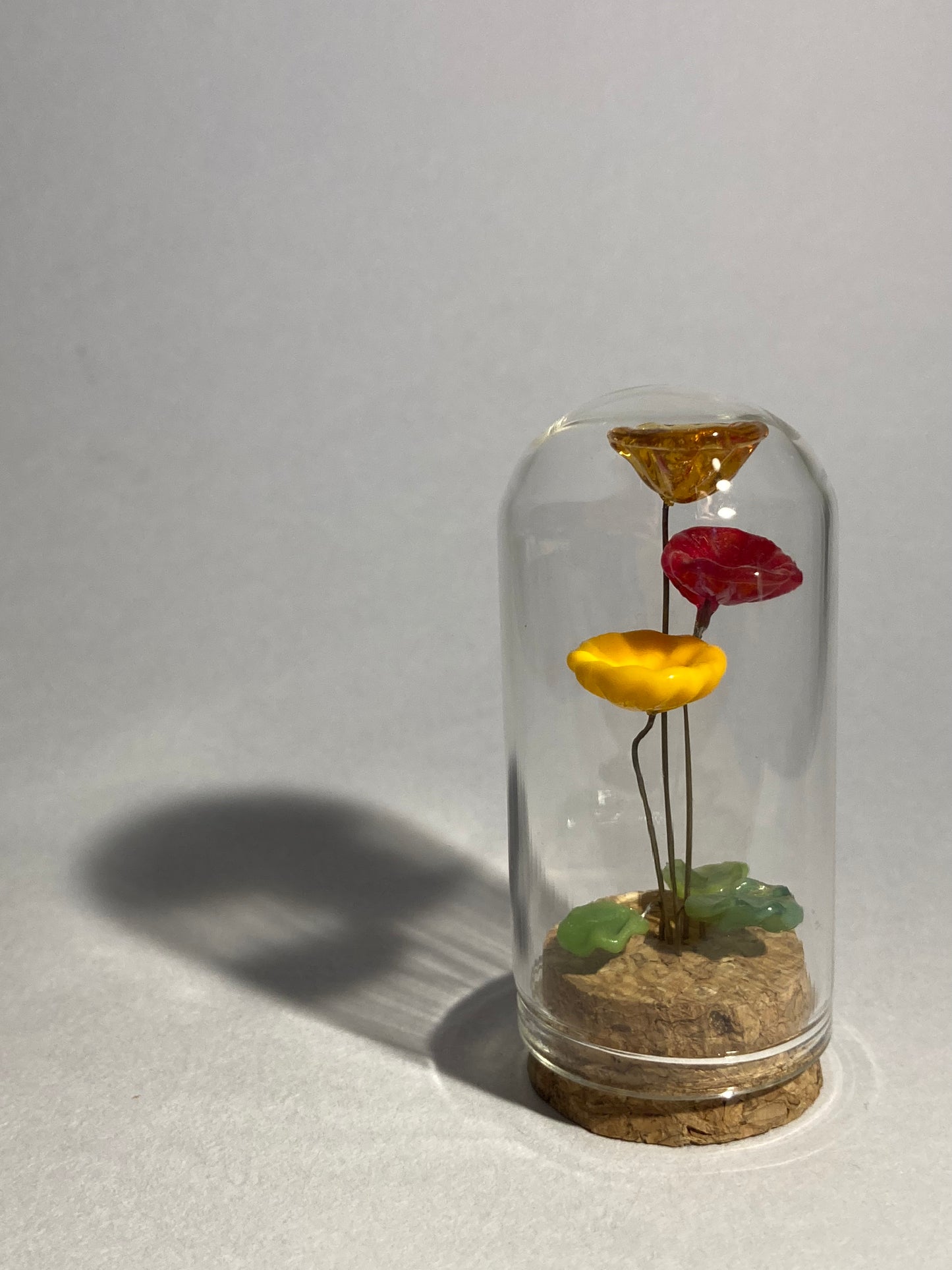 Fleurs oranges et rouges en verre sous cloches