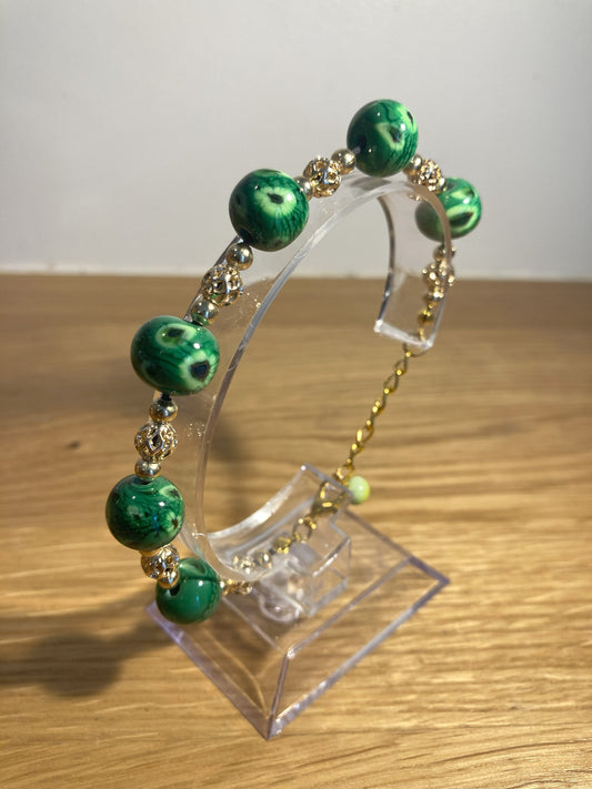 Bracelet doré avec perles vertes chamarrées en verre